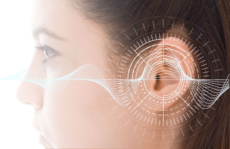Visualization of sound waves superimposed over a person's face in profile, centered on the ear
