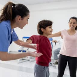Doctor and mom with a young boy practicing balance